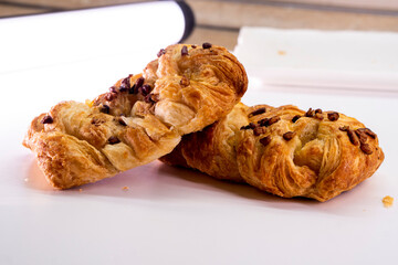 Fresh delicious puff pastry with maple syrup and nuts on white background