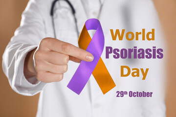 World Psoriasis Day (October, 29). Doctor holding orange-orchid awareness ribbon on dark beige background, closeup