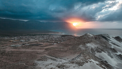 Stunning sunset over Socotra Islands coast, featuring dramatic clouds and rugged terrain