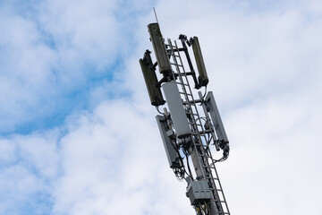 Obraz premium Cell tower stands tall against a cloudy sky in urban setting