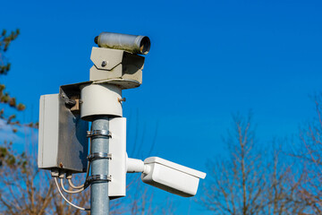 Security surveillance camera mounted on a pole against blue sky