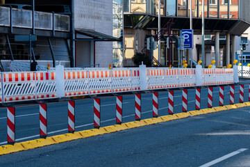 Construction barriers line the street outside a modern building