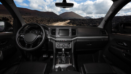 A black car with a large mountain in the background