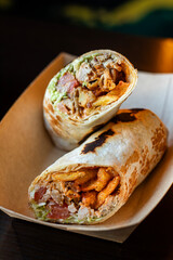 Breakfast falafel burrito wrap with fries, chicken and vegetables in a box. Tortilla wrap sandwich