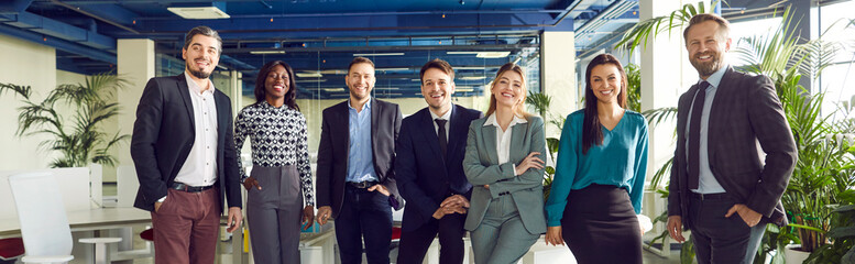 Group portrait of happy professional international business team standing together in row and...