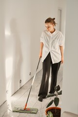 Portrait of a beautiful blonde girl cleaning the house, mopping the floors