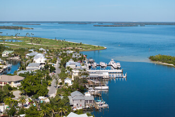 Expensive mansions between green palm trees on Gulf of Mexico shore in island small town Boca...