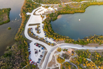Parking lot at Blind Pass beach on Manasota Key in Englewood. Tourists cars in front of ocean beach with soft white sand in Florida. Popular vacation spot at sunset
