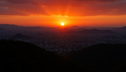Golden sun descends over horizon, radiating warmth as it kisses mountain sky is filled with tranquil hues