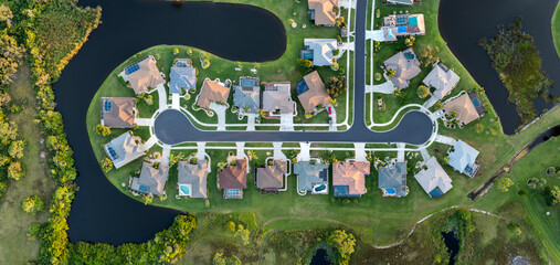 Upscale suburban homes with large backyards and green grassy lawns. Private residential houses in...