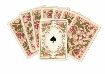 A fan of antique playing card backs with one card revealed.