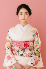 Fototapeta premium Japanese Beauty Model with Natural Dewy Skin, Young woman in colorful kimono against a pink background.