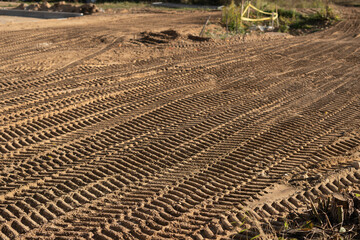 photo Close-up view of intricately patterned tire tracks imprinted on the sandy terrain at a...