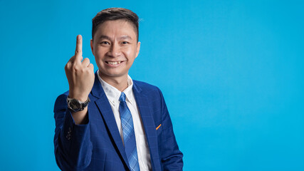 Handsome businessman shows middle finger, acts brash, provocative and has a rude attitude.