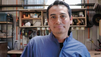 Confident latin worker smiling in his workshop
