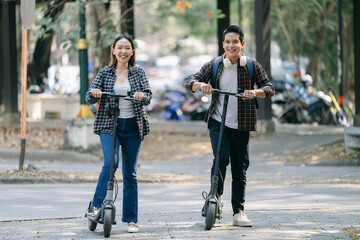 University students riding electric scooters, smiling and navigating park pathways, representing eco-friendly urban transportation during bright daylight hours