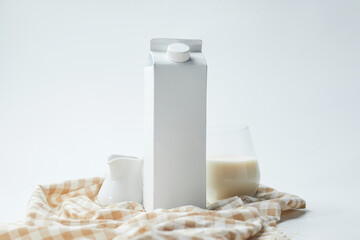 Milk Carton and Glass of Fresh Milk on a Checkered Cloth in a Minimalistic Setup With Soft Lighting