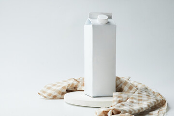 White Carton Milk Packaging on a Minimalist Setting With a Neutral Background and Checkered Cloth