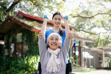 Obraz premium A woman in a wheelchair is being assisted by a woman in a blue shirt