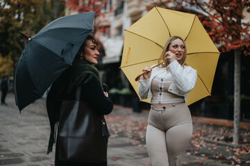 Two fashionable women enjoying a rainy autumn day together, holding colorful umbrellas while...