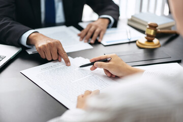 A man points to a contract on a table