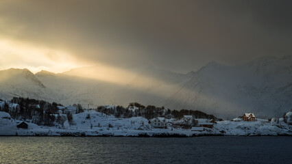 Norwegia. Senja. Langbaren. Norweski dom oświetlony promieniami słońca