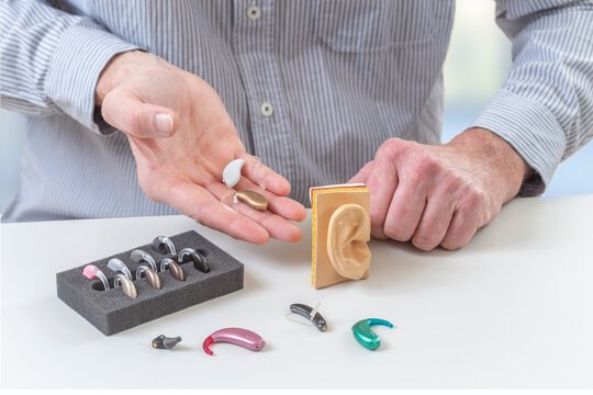 Demonstrating various styles of hearing aids