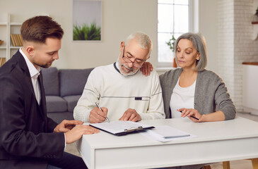 Fototapeta premium Elderly couple clients signs a contract with a real estate agent, financial consultant, or insurance adviser, at home. They finalize agreements related to real estate and financial matters.