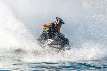 Obraz premium Professional jet ski racer is jumping on water surface at high speed