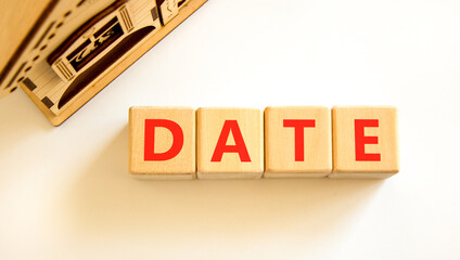 Date symbol. Concept word Date on beautiful wooden blocks. Beautiful wooden house. Beautiful white...