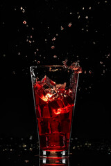 Red cocktail with ice, refreshing drink, alcoholic long drink