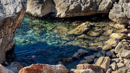 Crystal-clear rocky cove with vibrant water, ideal for summer nature retreats, tranquility, and leisure