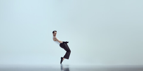 Dynamic photo of elegant dancer bending backward with controlled balance and expressive pose against white studio background. Concept of beauty and art, fashion and style, self-expression