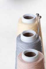 Balls of yarn. Beige, pink and gray. Space for text, banner. Metal knitting needles. Hobby concept. Metal knitting needles. Vertical photo.