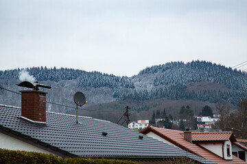 Winter Hills Overlooking a Small Town. A picturesque small town nestled at the foot of snow-covered...
