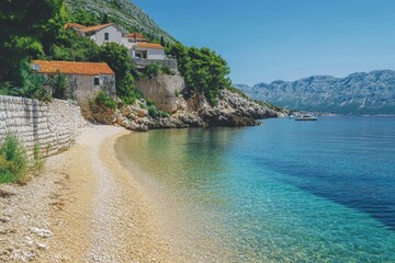 A house perched atop a cliff overlooking the ocean, with a beach below