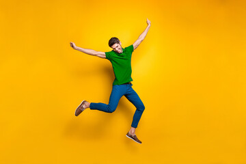 Fototapeta premium Full length body size photo of cheerful positive attrative man in blue pants trousers leather shoes flying jumping running up to his dream isolated over vivid color background