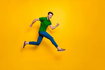 Full lenghtb body size side profile photo of hurrying urgent white casual guy running jumping in blue pants trousers purple t-shirt footwear isolated over vivid color background