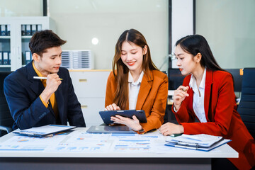 Three Asian business professionals gather in boardroom for annual meeting, discussing strategic goals, future projections while proposing ideas, engaging in decision-making for corporate growth.