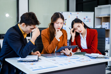 Three Asian business professionals gather in boardroom for annual meeting, discussing strategic goals, future projections while proposing ideas, engaging in decision-making for corporate growth.
