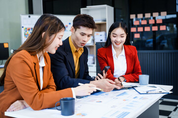 Three Asian business professionals gather in boardroom for annual meeting, discussing strategic...