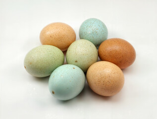 colored eggs in a pile on a white background.