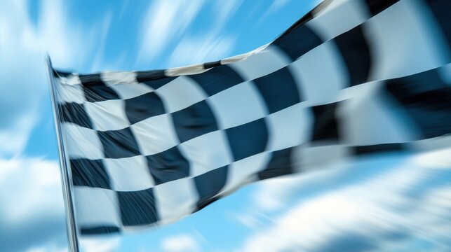 A blurred checkered flag waves against a bright blue sky, symbolizing competition and victory.