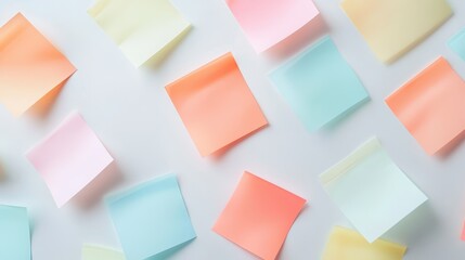 Colorful sticky notes in pastel shades scattered on a white surface, creating a vibrant and organized texture.