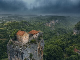 Fototapeta premium forest covered gorge and house on a rock pillar, cliff house on top, aerial view