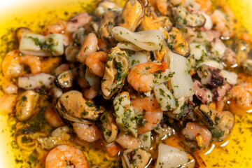 A plate of shrimp and other seafood. There are also some other seafood items on the plate