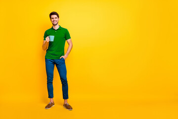 Fototapeta premium Full length body size view of his he nice attractive cheerful cheery content guy drinking coffee spending good day isolated over bright vivid shine vibrant yellow color background