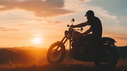 Silhouetted Biker Riding Motorcycle into the Magnificent Sunset on a Winding Country Road Through the Scenic Rural Landscape