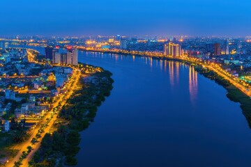 Fototapeta premium Panoramic Night View of a Vibrant Financial Hub with City Lights Reflecting on the River in Stunning Clarity, Captured with Advanced Imaging Technology
