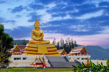 Naklejka premium Golden buddha statue at huay mongkol temple in hua hin, thailand amidst scenic twilight